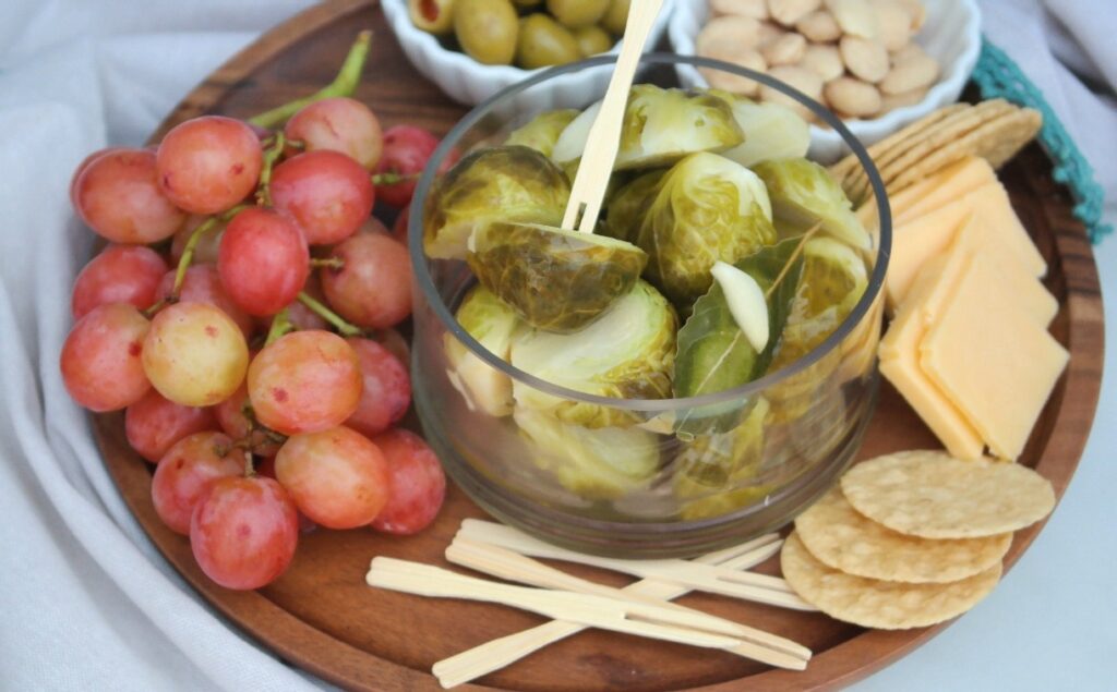 Wooden plate with appetizers like cheese and crackers ready to be eaten. 