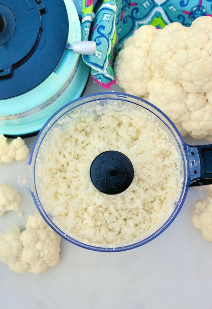 An overhead view of cauliflower riced in a food processor. 
