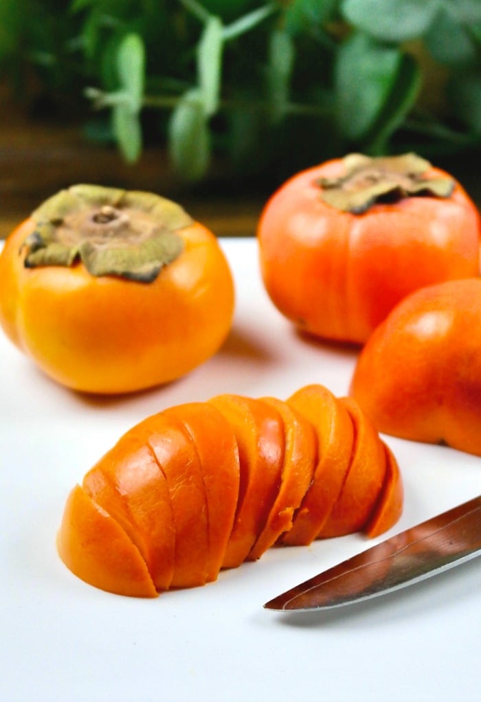 Sliced persimmon on a cutting board.