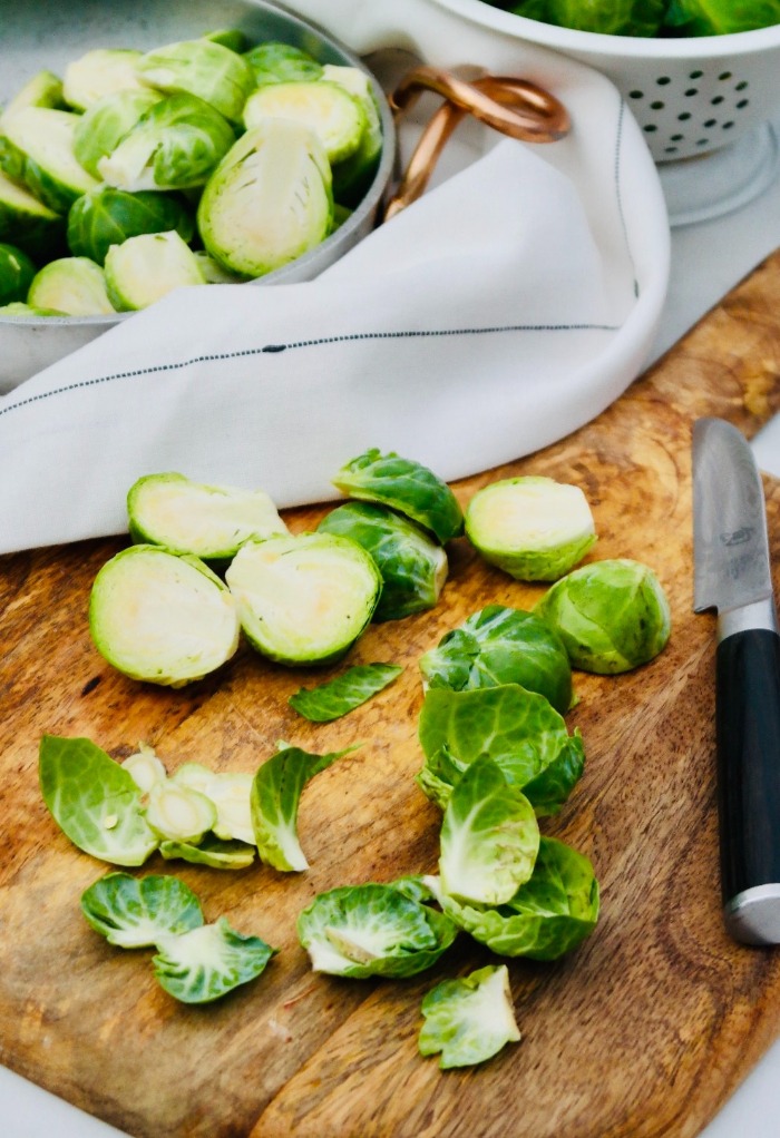 Here brussels sprouts are cleaned and sliced in half to be steamed. 