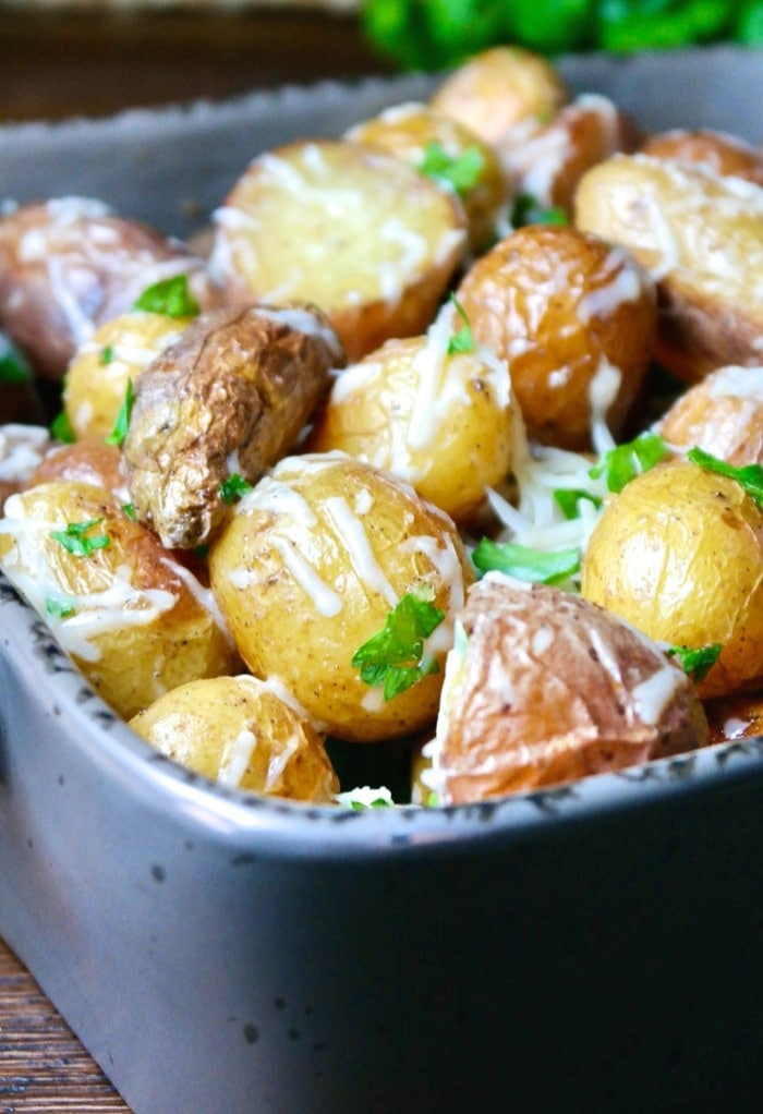 Baby potatoes with parmesan cheese in a gray serving dish. 