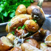 A spoonful of roasted fingerling potatoes ready to be served.