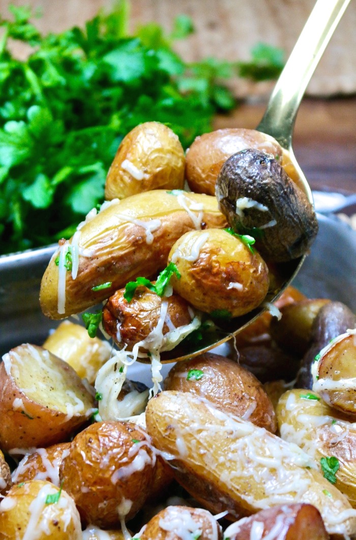 A spoonful of roasted fingerling potatoes ready to be served.