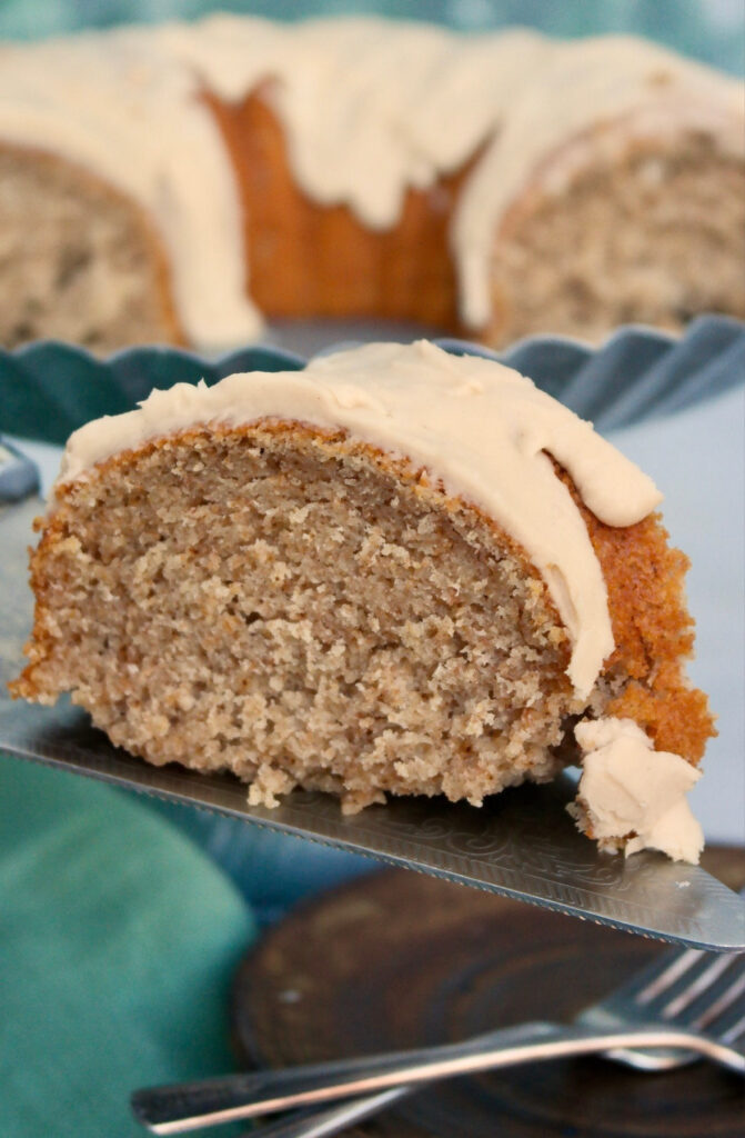 A silver cake server under a slice of cake.