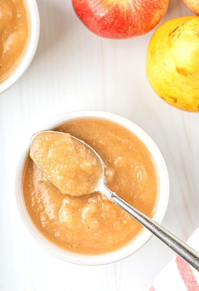 A spoonful of homemade applesauce in a small white bowl. 