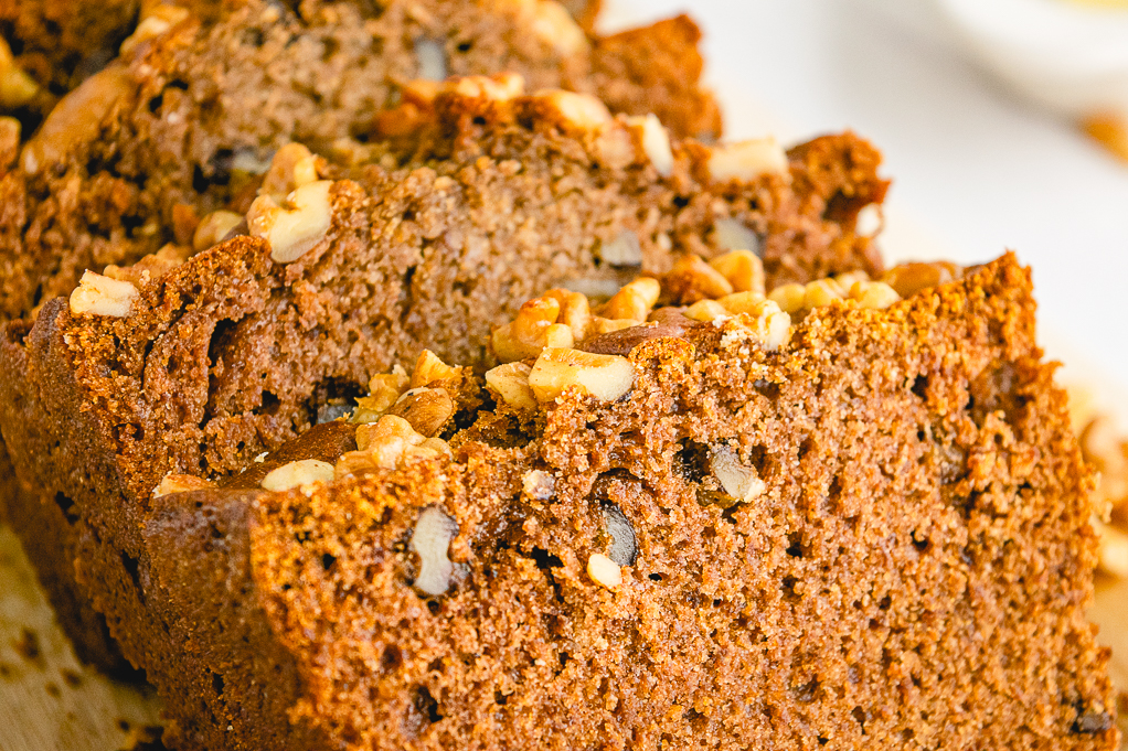 Close up view of sliced persimmon bread with nuts. 