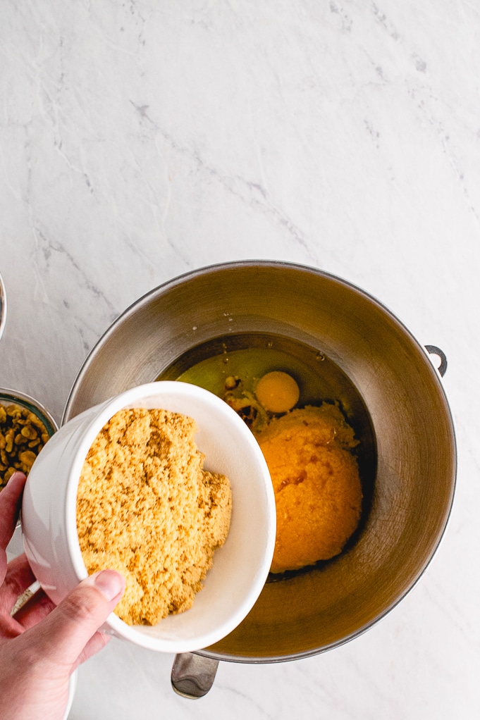 Adding flour to wet mixture for bread batter.