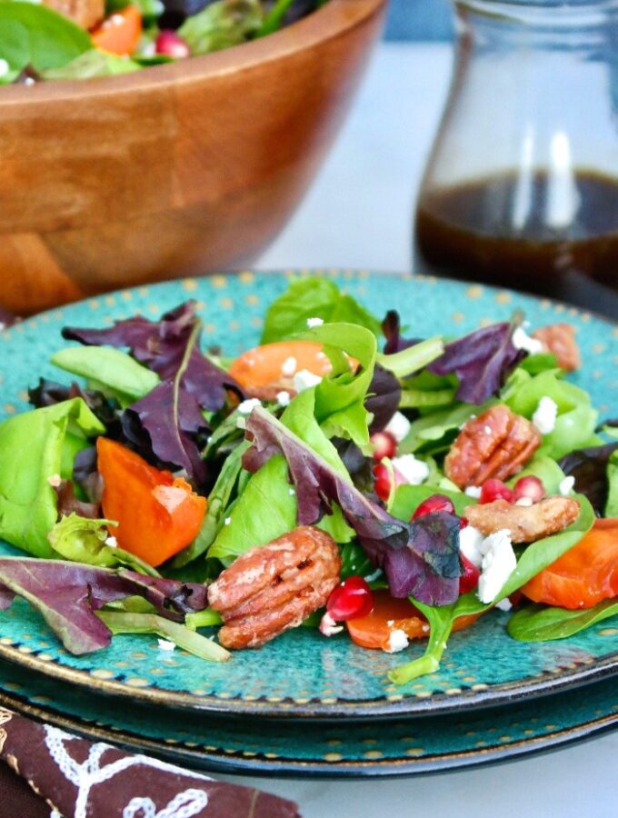Persimmon salad on a teal plate.