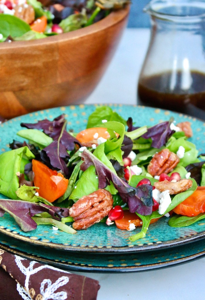 Persimmon salad on a teal plate.