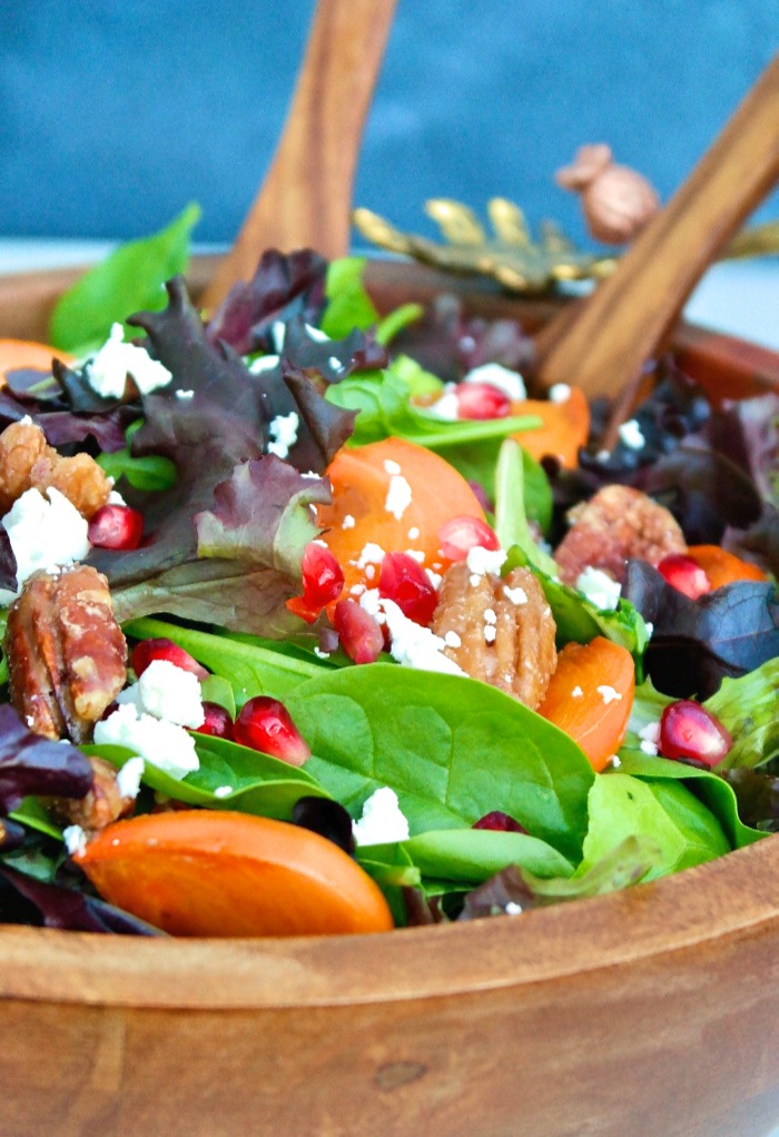 Fresh green salad greens with persimmons. 