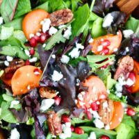 Top view of a brown wooden bowl filled with persimmon salad.