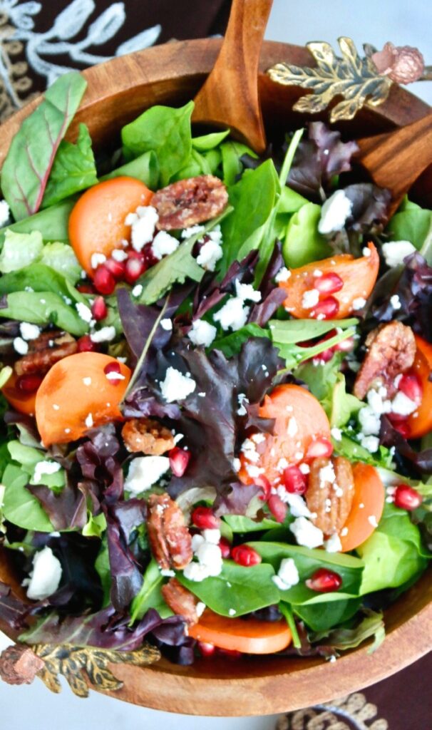 Top view of a brown wooden bowl filled with persimmon salad.