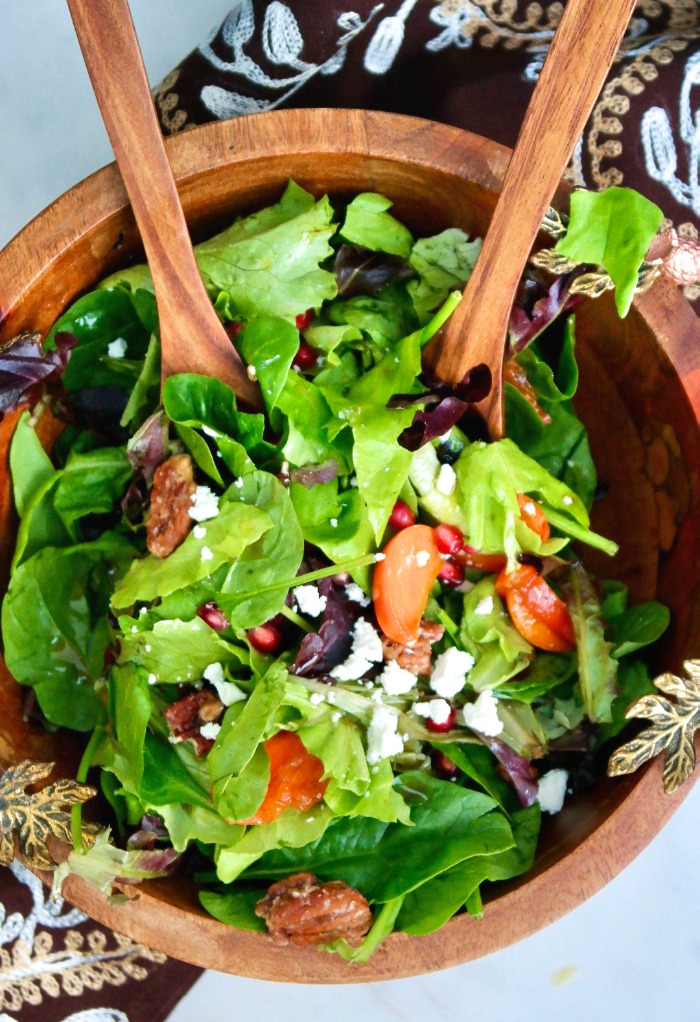 Fresh persimmon salad in a brown wood bowl. 