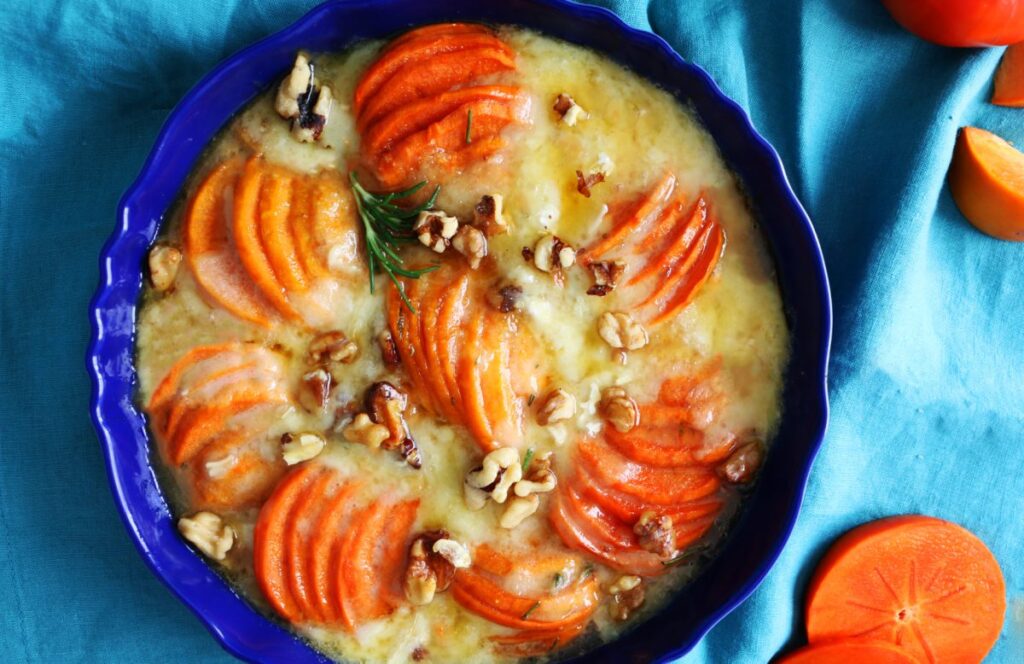 Appetizer of baked brie in a blue serving dish. 