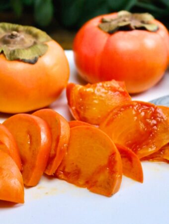 sliced fuyu persimmon on a white cutting board.