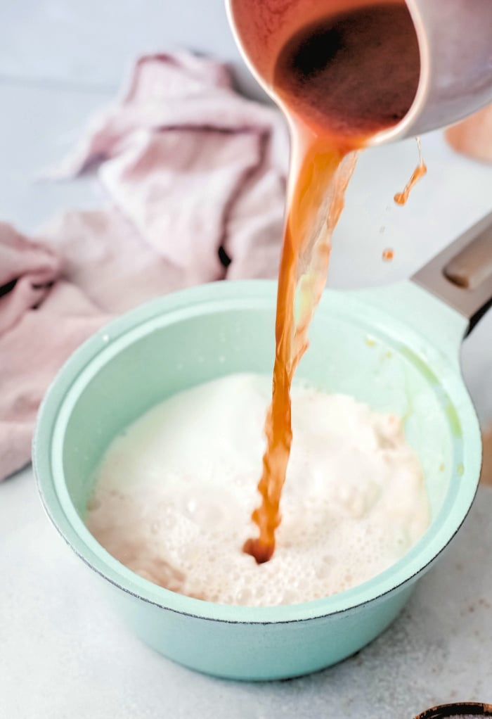 Adding espresso to warm milk for caramel latte