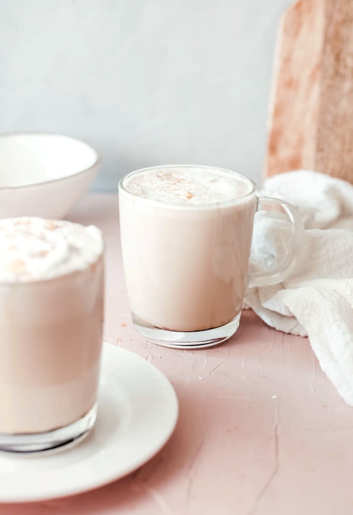 Whipped cream topping coffee drinks in clear mugs. 