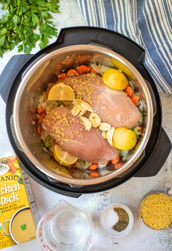Here we add all the ingredients to an Instant Pot to make chicken soup with lemon. 