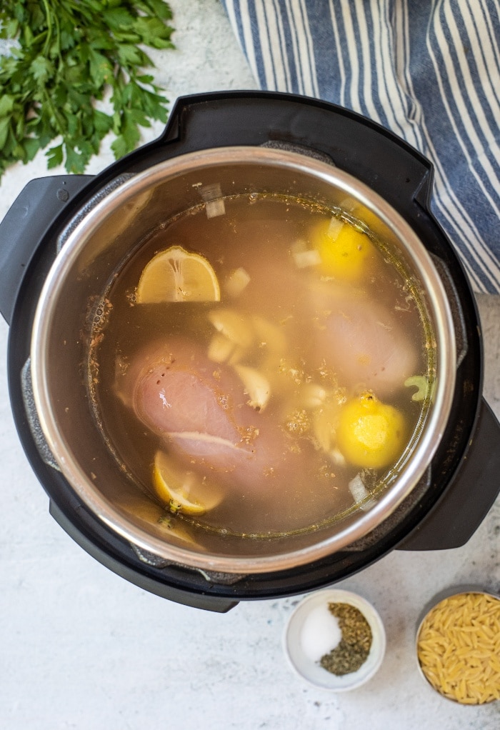 Add broth to chicken soup recipe before closing the lid on the Instant Pot.