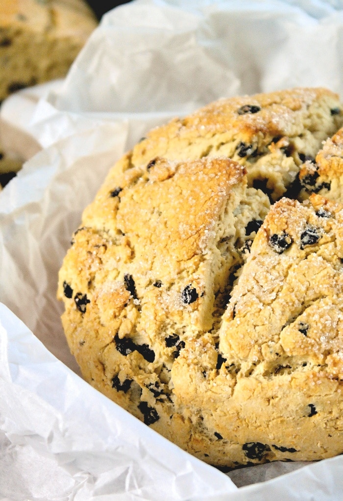 A close up view of Irish soda bread in white parchment paper.