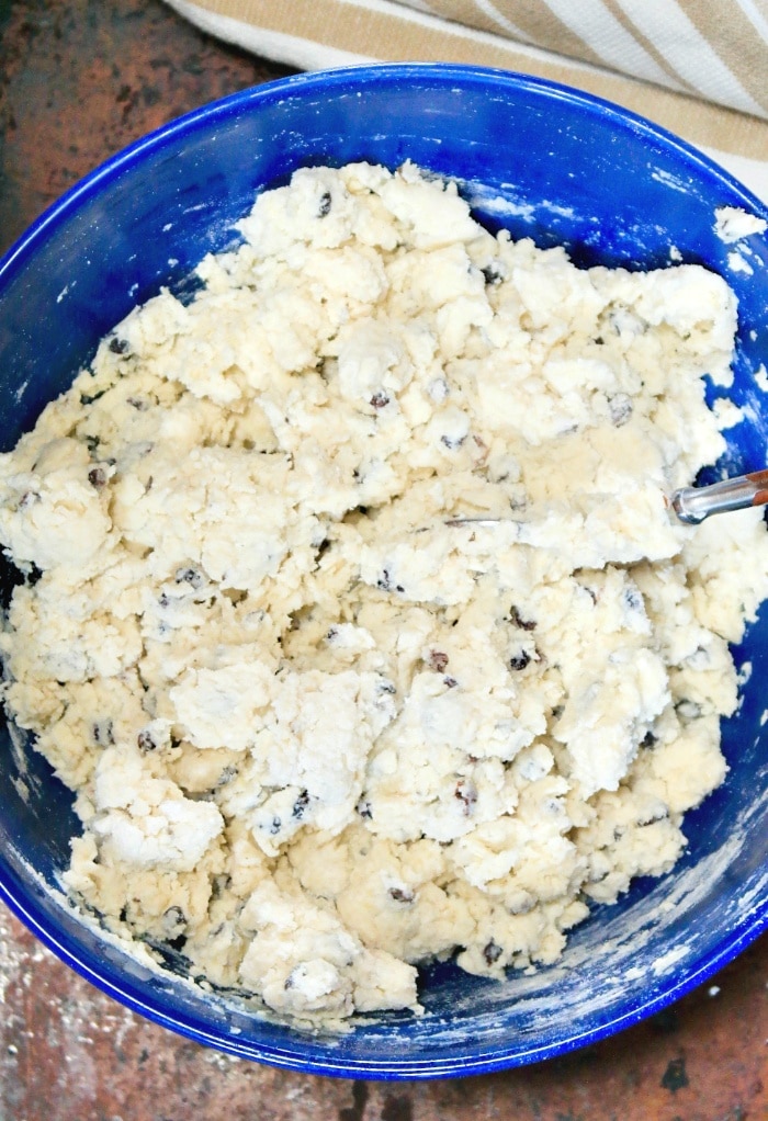 Wet and dry ingredients in a blue mixing bowl to make quick bread. 