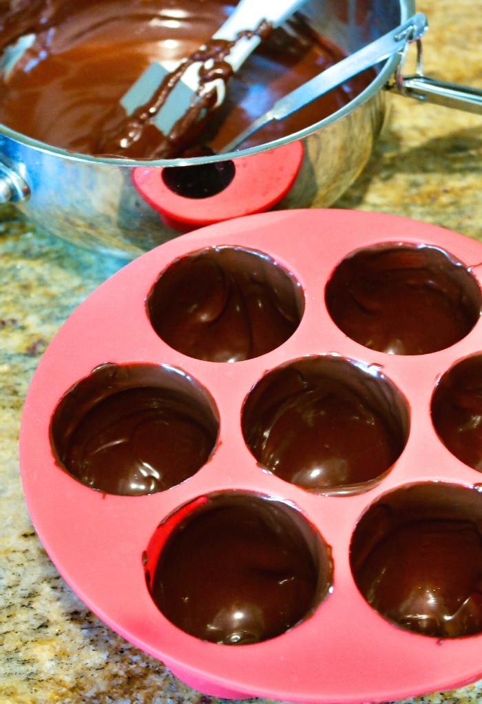 Melted chocolate in an silicone mold to make cocoa bombs. 