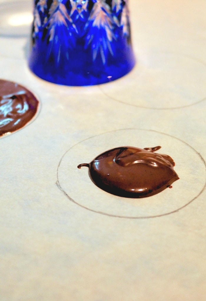 A round circle on parchment paper to make a disk to cover chocolate mold. 