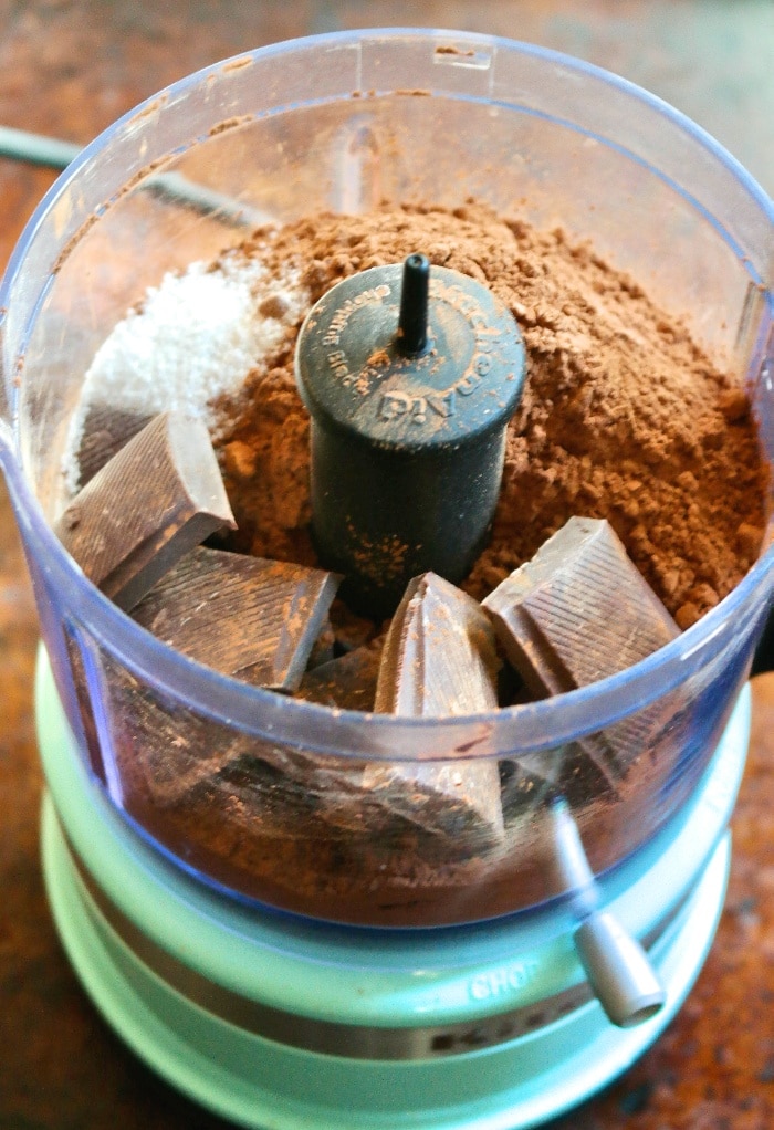 Keto hot chocolate ingredients in a food processor ready to blend into cocoa mix. 