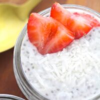 Top view of a small mason jar filled with a dairy free pudding topped with slices of strawberries.