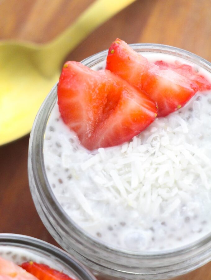 Top view of a small mason jar filled with a dairy free pudding topped with slices of strawberries.