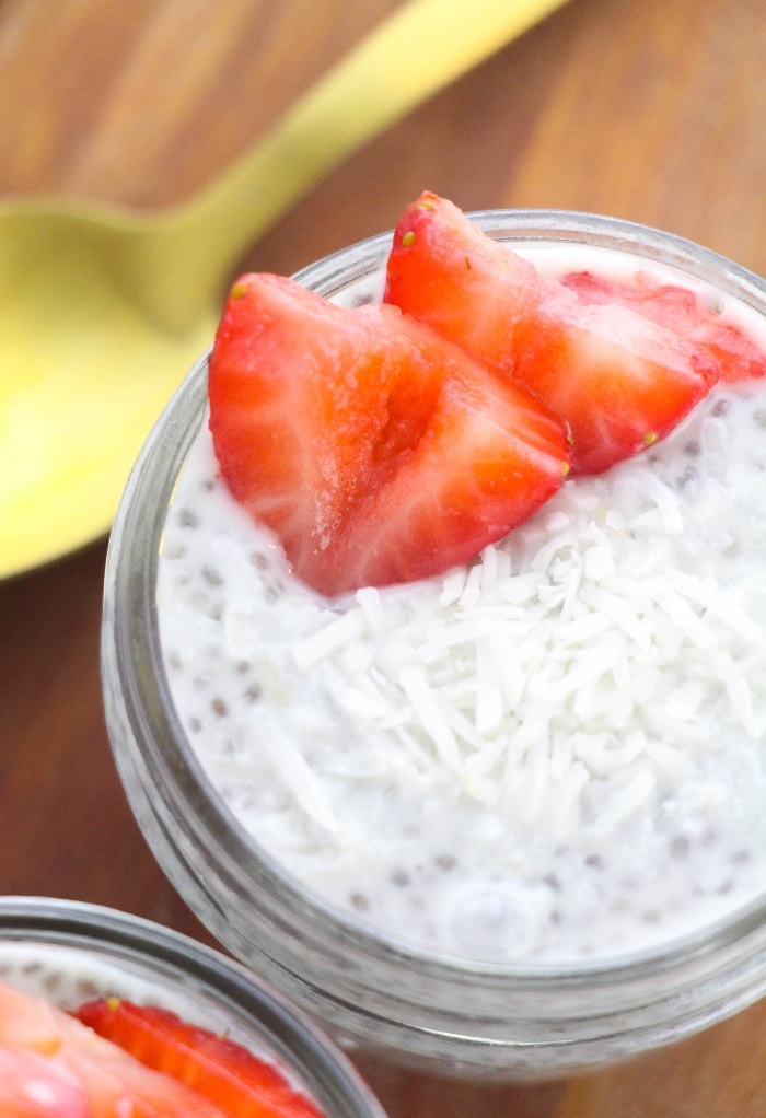 Top view of a small mason jar filled with keto chia pudding topped with slices of strawberries. 