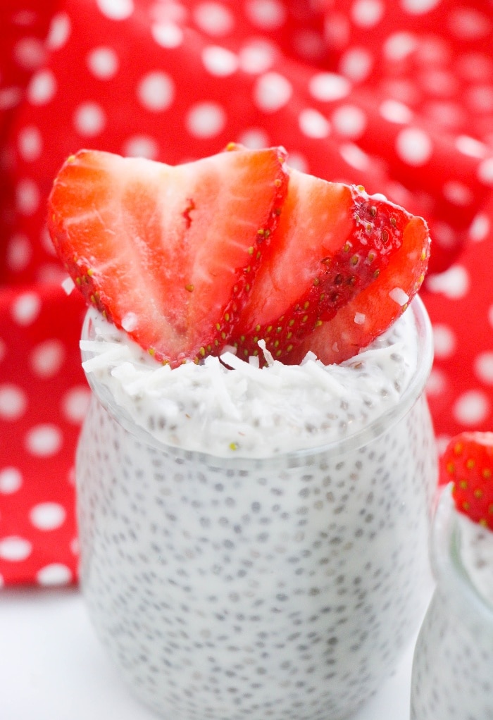 Small jars filled with chia pudding with a red and white napkin in the background. 