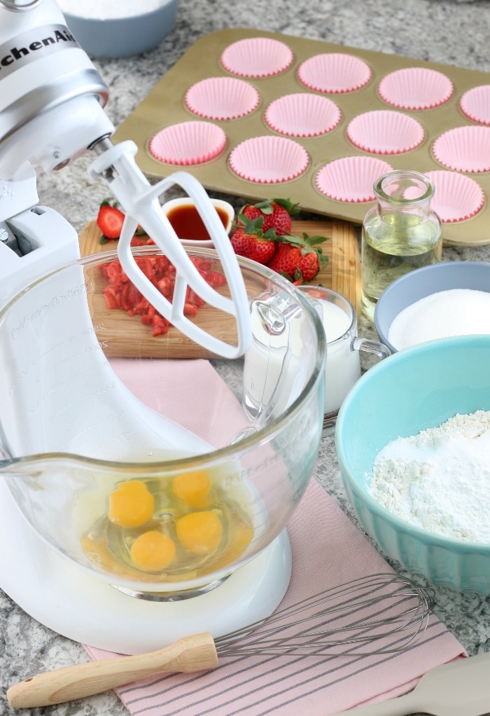 Raw eggs in a mixer stand ready to be beat for baking. 