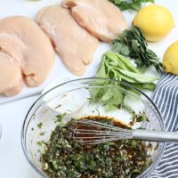 A mixture of marinade for chicken breasts in a clear mixing bowl.