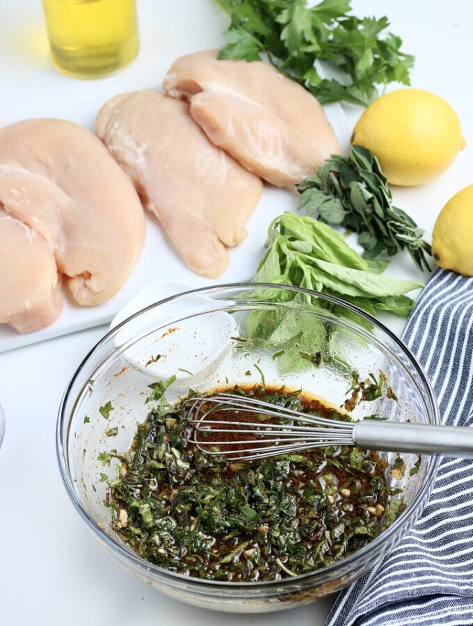 A mixture of marinade for chicken breasts in a clear mixing bowl.