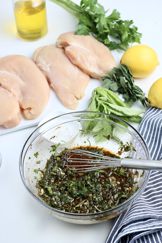 A mixture of marinade for chicken breasts in a clear mixing bowl. 