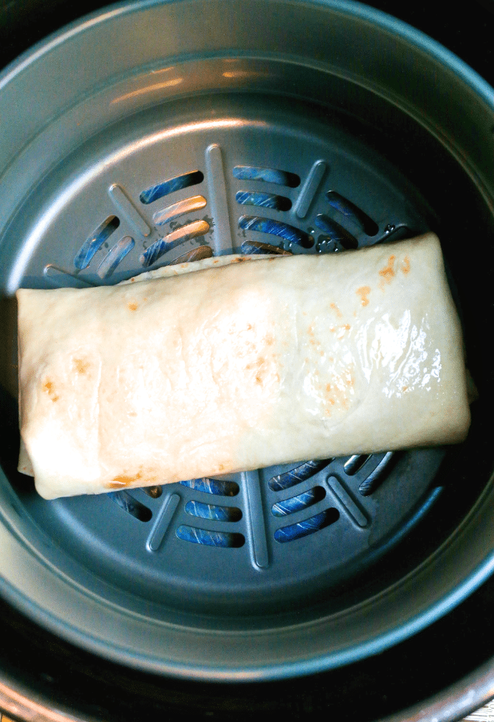 Chimichanga in an air fryer ready to be cooked.