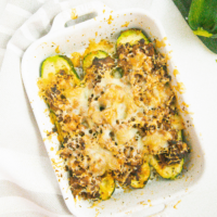 Cooked air fryer zucchini boats in a white serving dish.