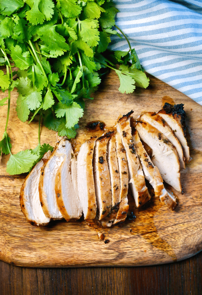 A top view of sliced chicken on a cutting board that was air fried. 