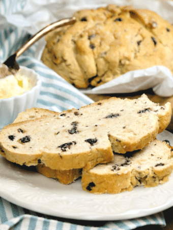 Close view of two slices of gluten free Irish soda bread on a white plate.