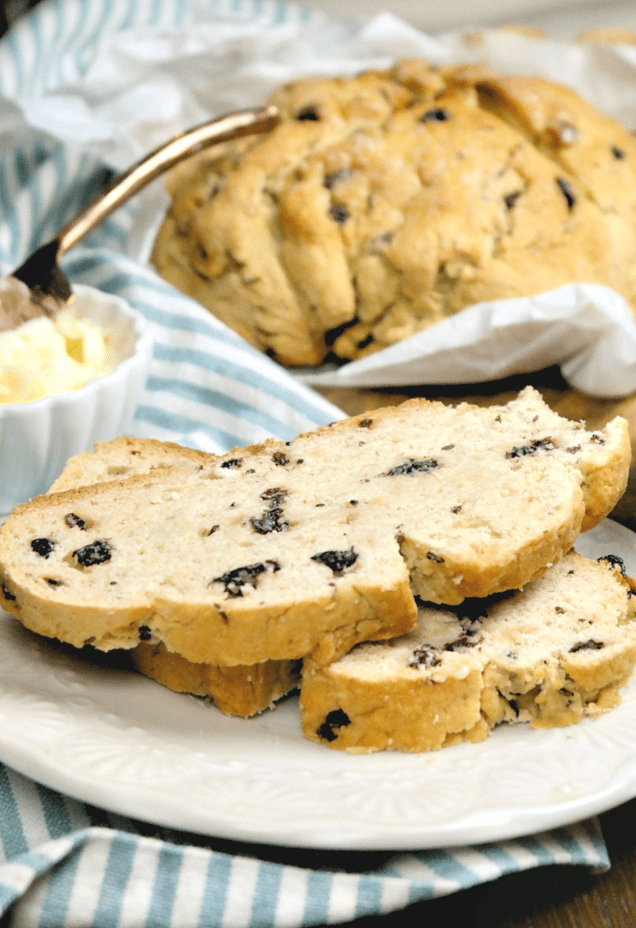 Close view of two slices of gluten free Irish soda bread on a white plate.