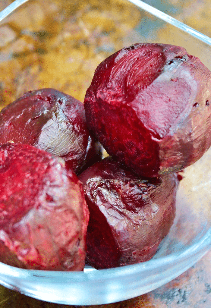 Cooked roasted beets in a clear glass bowl. 