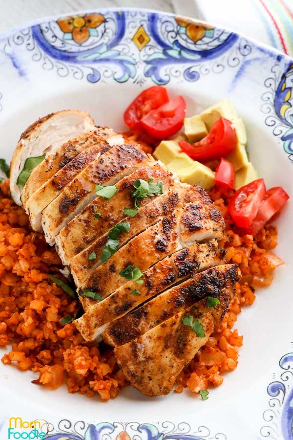 Top view of blackened chicken breasts cut into slices and surrounded by a red cauliflower rice - low carb chicken recipes