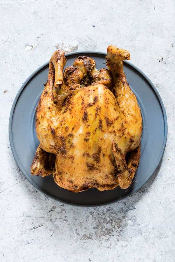 Top view of a cooked whole chicken on a blue plate - low carb chicken recipes