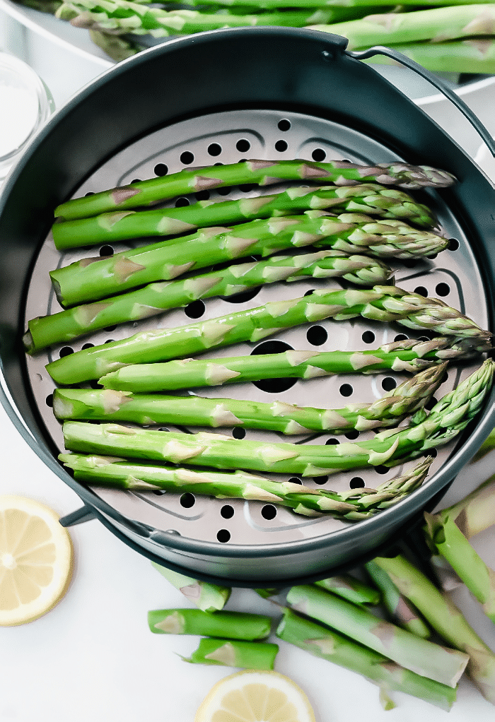 Fresh asparagus spears in an air fryer ready to cook. 