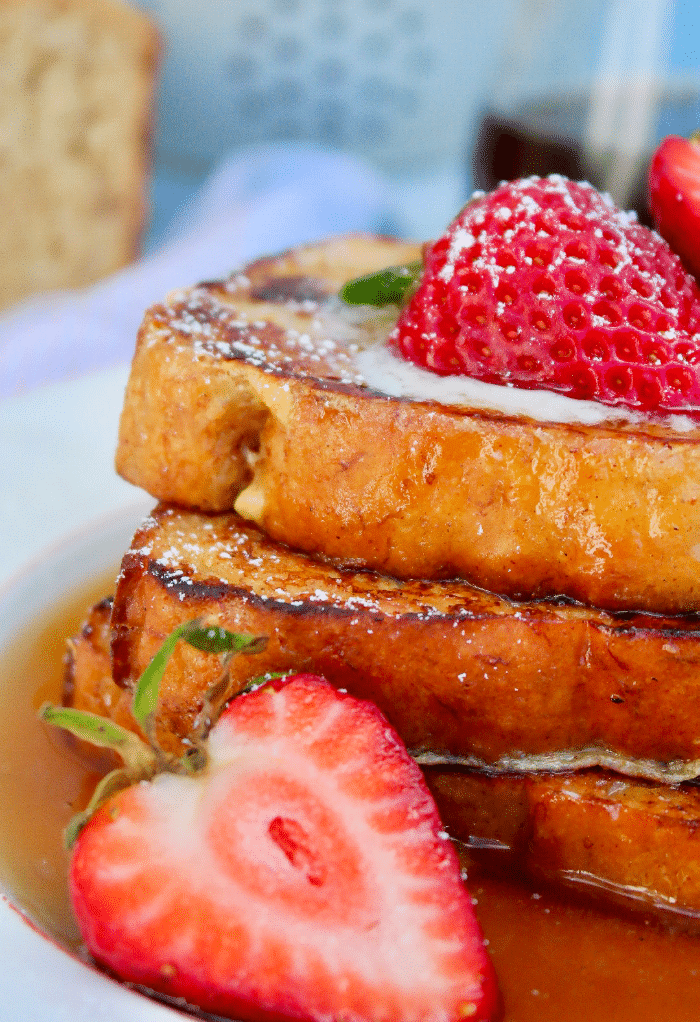 Syrup over French toast topped with strawberries. 