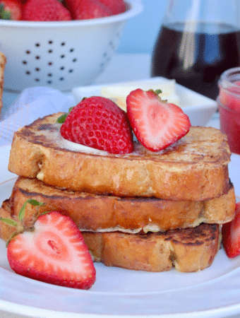 Keto French Toast on a white plate topped with strawberries.