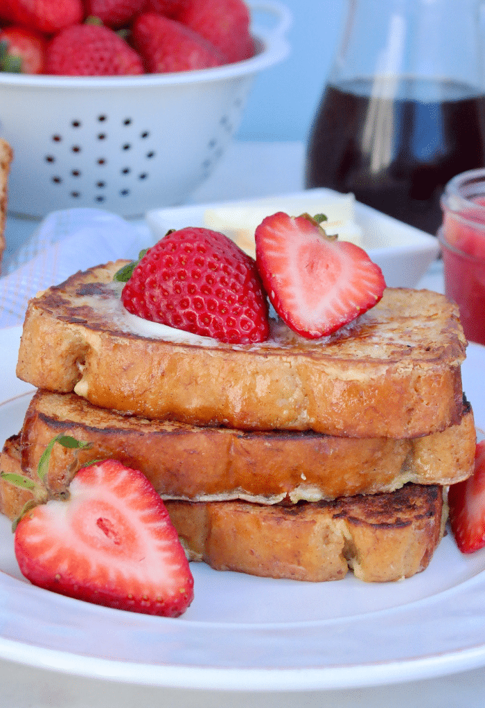 Keto French Toast on a white plate topped with strawberries.