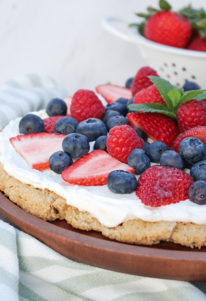 A side view of half of a dessert pizza topped with fruit. 