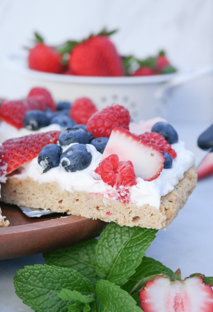  A slice of a dessert pizza topped with fresh fruit. 